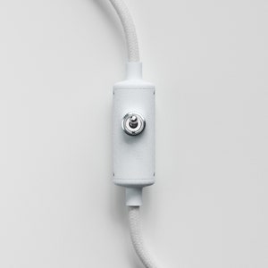 May include: White cord with a white inline switch with a silver knob. The switch is on a white background.