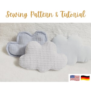 May include: Three soft, cloud-shaped pillows in light blue and white waffle fabric. Sewing pattern and tutorial included.  Flags of the United States and Germany are shown in the bottom right corner.