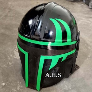 May include: A black helmet with green accents. The helmet has a glossy finish and features green stripes and angular designs. The initials "A.H.S" are printed in white on the lower front of the helmet. The helmet is likely for cosplay or costume use.