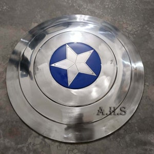 Pu&ograve; includere: Uno scudo di Captain America argentato con una stella blu al centro. Lo scudo ha un bordo rialzato ed &egrave; fatto di metallo. Lo scudo &egrave; firmato "A.H.S."