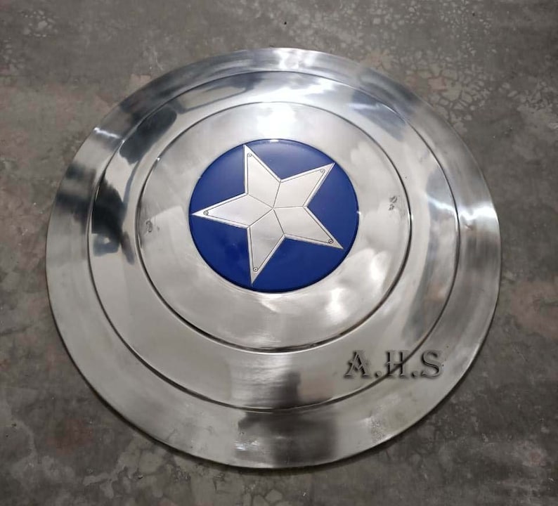 Pu&ograve; includere: Uno scudo di Captain America argentato con una stella blu al centro. Lo scudo ha un bordo rialzato ed &egrave; fatto di metallo. Lo scudo &egrave; firmato "A.H.S."