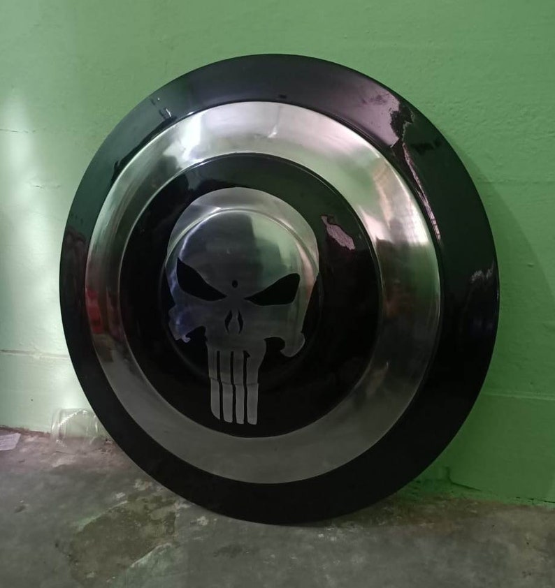 May include: A black and silver Captain America shield with a silver skull design in the center.
