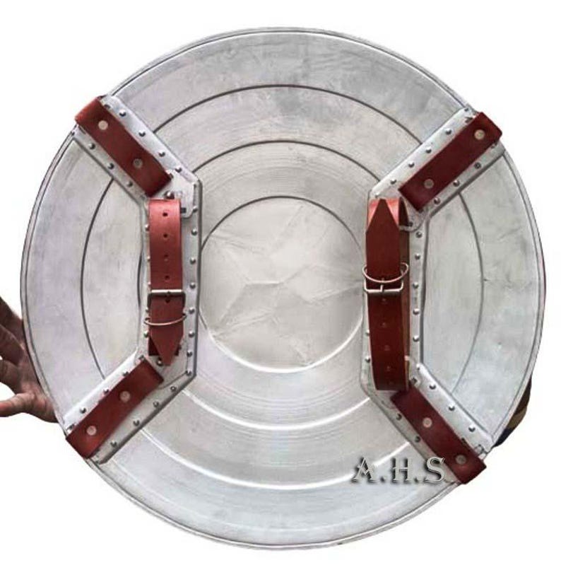 Pu&ograve; includere: Uno scudo di Captain America argentato con cinturini in pelle rossa e rivetti. Lo scudo ha un design circolare con una stella al centro. Lo scudo &egrave; in metallo e ha un aspetto usurato. Lo scudo ha il testo "A.H.S." in basso.