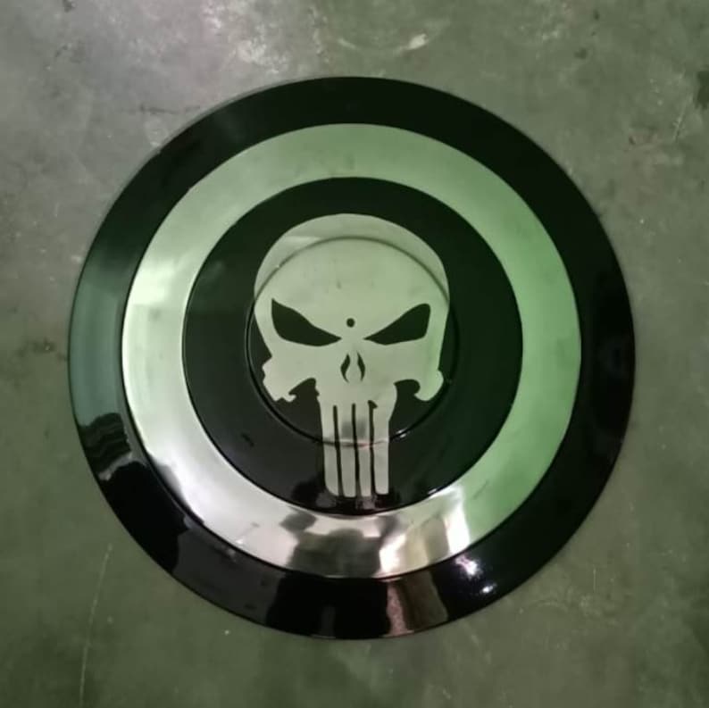 May include: A black and silver round shield with a white skull and crossbones design in the center.