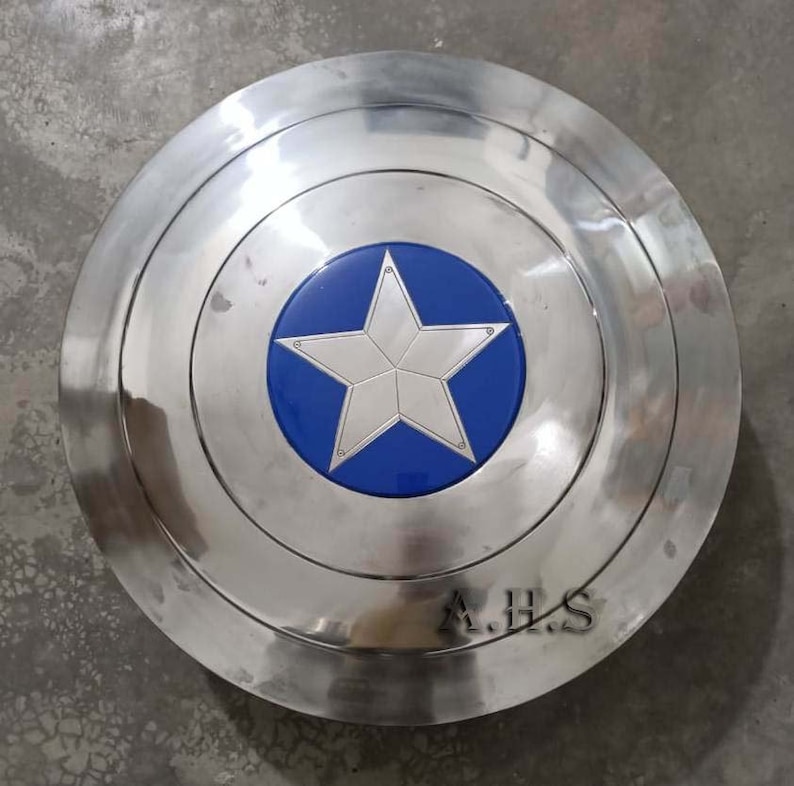 Pu&ograve; includere: Uno scudo di Captain America argentato con una stella blu al centro. Lo scudo ha un bordo rialzato ed &egrave; fatto di metallo. Lo scudo ha le lettere A.H.S. incise sul fondo.