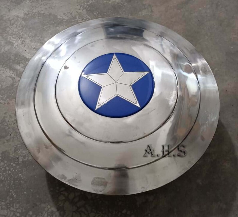 Pu&ograve; includere: Uno scudo di Captain America argentato con una stella blu al centro. Lo scudo ha un bordo rialzato e le lettere A.H.S. sono incise sul fondo.