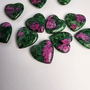 May include: A collection of 10 green and pink heart-shaped stones. The stones are polished and have a smooth surface.