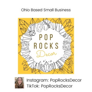 May include: A yellow square with a black and white illustration of crystals forming a circle around the text "POP ROCKS Decor". The text "Ohio Based Small Business" is above the square. Below the square is the text "Instagram: PopRocksDecor TikTok: PopRocksDecor".