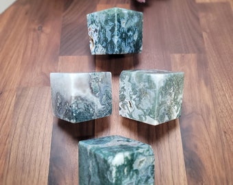 May include: Four green and white moss agate cubes. The cubes are polished and have a natural, organic look.