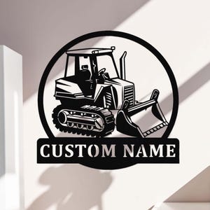 May include: Black and white silhouette of a tractor with a bulldozer blade, inside a circle with the text "CUSTOM NAME" below.