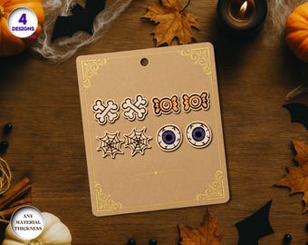 May include: A set of four Halloween-themed wooden earring designs on a brown card. The designs include bone shapes, candy, spiderwebs, and eyeballs. The card has a decorative gold border and a hole at the top.