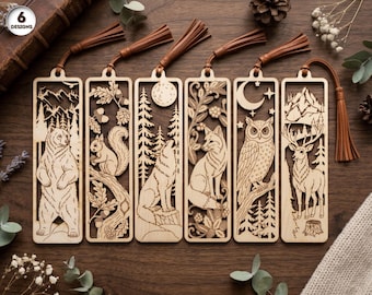 May include: Six rectangular wooden bookmarks featuring intricate laser-cut designs of a bear, a squirrel, a wolf, a fox, an owl, and a deer. Each bookmark includes a brown faux leather tassel attached to the top and displays the text 6 DESIGNS.
