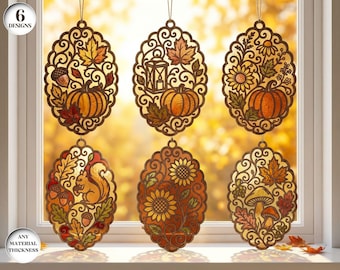 May include: Six oval-shaped hanging ornaments featuring intricate laser-cut brown frames with autumn-themed designs including pumpkins, sunflowers, a squirrel, acorns, mushrooms, and a lantern, all displayed against a bright window background.