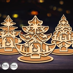 Può includere: Tre decorazioni per l'albero di Natale in legno con intricati disegni ritagliati che raffigurano scene della natività. Ogni albero ha un design diverso, tra cui angeli, cammelli e la sacra famiglia. Gli ornamenti sono su una superficie di legno, con il testo "3mm material", "4mm material" e "6mm material".
