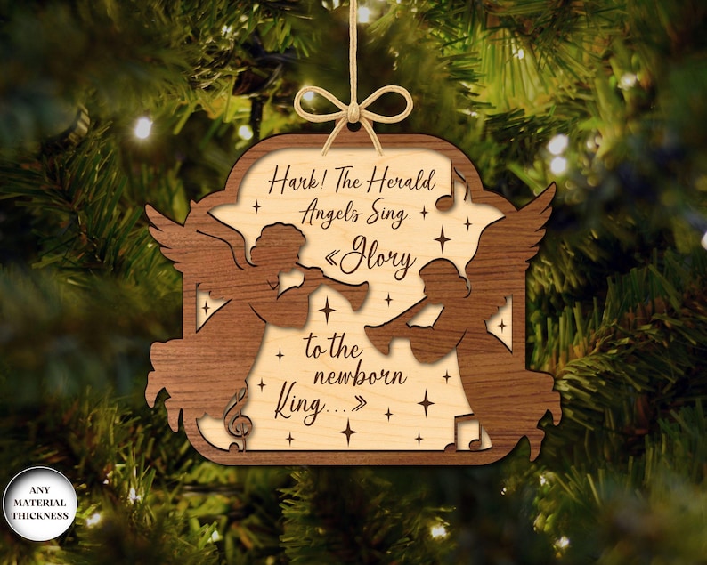 May include: Wooden Christmas ornament with a light wood center and a dark wood border. The ornament features two angel silhouettes playing trumpets, with the text "Hark! The Herald Angels Sing. Glory to the newborn King..." and star accents.