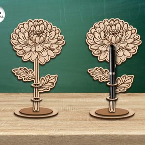 Pu&ograve; includere: Due portapenne in legno a forma di fiore, con uno spessore del materiale di 3 mm. Ogni portapenne presenta un design dettagliato di un fiore di crisantemo con una fessura per penne al centro.