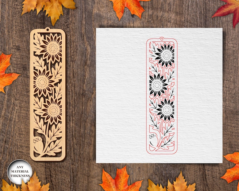May include: Wooden bookmark with a sunflower design. The bookmark is light brown and features cut-out sunflowers and leaves. A second bookmark design is shown in red and black on a white background. The words "ANY MATERIAL THICKNESS" are in a circle.