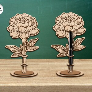 Pu&ograve; includere: Due portapenne in legno a forma di peonie con il testo "Grazie all'insegnante" sui gambi. I portapenne sono spessi 3 mm e hanno una base per stare in piedi.