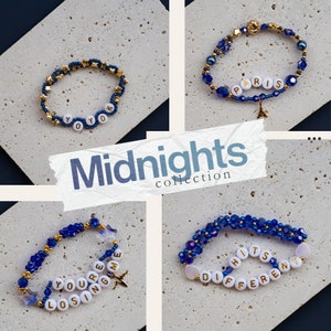 May include: Four blue and gold beaded bracelets with white letter beads spelling out "Yoyo", "Paris", "You're Losing Me", and "Different Hits". The bracelets are arranged on a white tiled background with the text "Midnights collection" in a white and black font.