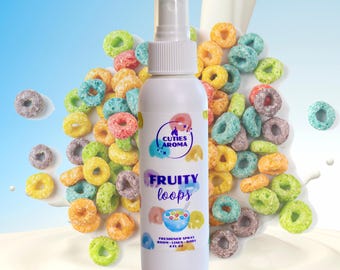 May include: A white spray bottle labeled "Cuties Aroma Fruity Loops Freshener Spray" with colorful cereal pieces scattered around it. The bottle has a white cap and a blue and white background.