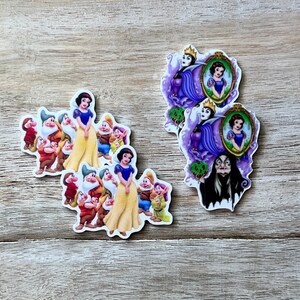 May include: Two sets of stickers featuring characters from the fairy tale Snow White. One set features Snow White and the Seven Dwarfs, the other features the Evil Queen and Snow White in a mirror.