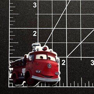 Puede incluir: Un cami&oacute;n de bomberos rojo con una cara sonriente y una escalera en el lateral. El cami&oacute;n tiene un parachoques blanco y faros.