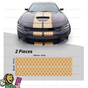 Può includere: Due pezzi di adesivi per auto in vinile a nido d'ape in oro e nero. Gli adesivi sono lunghi 160 cm e larghi 50 cm. Gli adesivi sono mostrati sul cofano di un'auto nera.