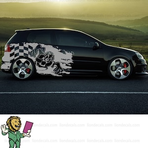 May include: Black car with a cartoon character and checkered flag graphic decal on the side. The decal is in gray and white. The car is on a black asphalt road.