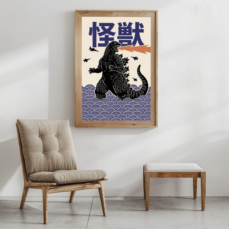 以下が含まれることがあります： オレンジ色の火の息、日本語のテキスト、青い波模様が描かれた黒いゴジラのイラストが特徴の額入りアートプリント。 アートワークはクリーム色の背景にあり、天然木で額装されています。