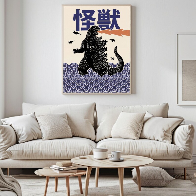 以下が含まれることがあります： 黒いゴジラのイラスト、オレンジ色の火の息、日本語のテキストが描かれた額入りのアートプリント。 作品はクリーム色の背景、青い波模様、小さな黒い飛行機のシルエットが特徴です。 部屋の装飾に最適です。