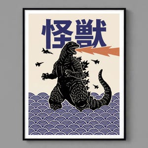 A art print featuring a black Godzilla illustration with Japanese text. The artwork depicts Godzilla in blue and white waves, with jets overhead and orange fire emanating from its mouth.