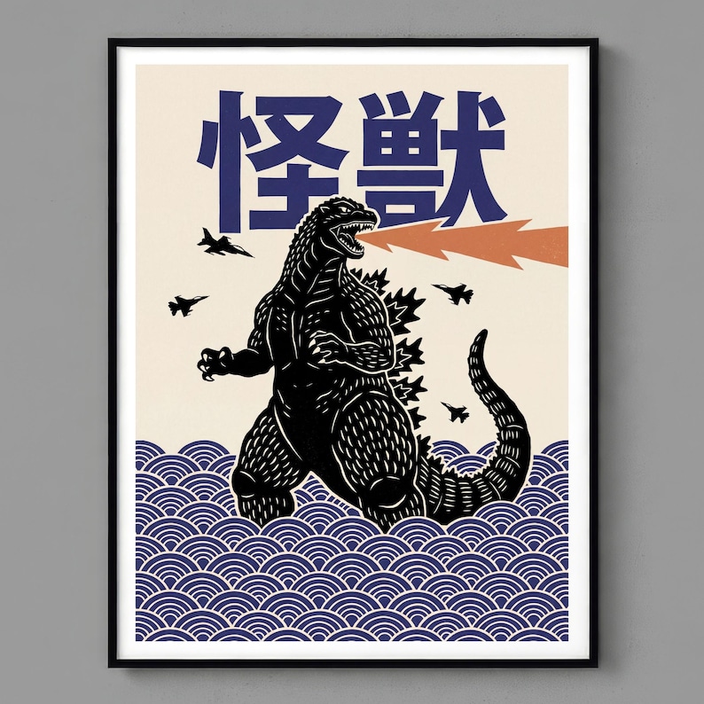 A art print featuring a black Godzilla illustration with Japanese text. The artwork depicts Godzilla in blue and white waves, with jets overhead and orange fire emanating from its mouth.
