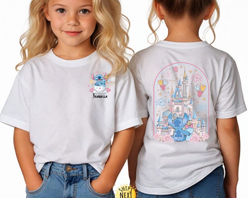 May include: White t-shirt featuring a cartoon Stitch design. The front of the shirt shows Stitch in a teacup with the name "Isabella". The back of the shirt displays a castle scene with Stitch, balloons, and fireworks.