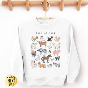 K&ouml;nnte beinhalten: Wei&szlig;er Pullover mit einer Grafik von Nutztieren und ihren Namen. Der Text "Farm Animals" befindet sich oben auf der Grafik.