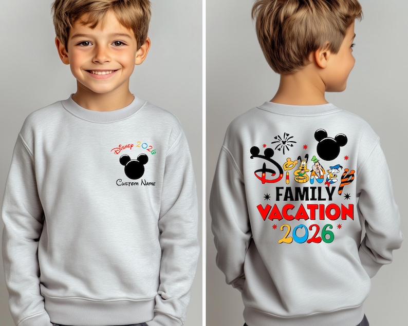 May include: A light gray sweatshirt featuring a black Mickey Mouse silhouette and the text "Disney 2026" in red, green, and black. The back of the sweatshirt displays "Disney Family Vacation 2026" with Mickey Mouse and friends.