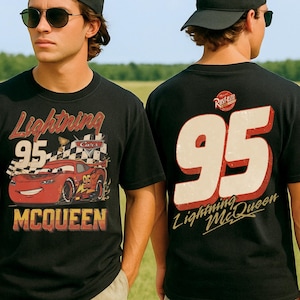 May include: A black t-shirt featuring a graphic of the red race car Lightning McQueen with the number 95, a checkered flag, and the text Lightning McQueen on the front, and a large number 95 with the text Lightning McQueen on the back.