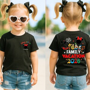 May include: Black t-shirt with a Minnie Mouse graphic and the text "Disney 2026" on the front. The back of the shirt features the text "Disney Family Vacation 2026" with various Disney character graphics. The child is wearing denim shorts.