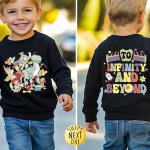 May include: Black sweatshirt with a colourful graphic of Toy Story characters on the front and the text "To Infinity and Beyond" on the back.