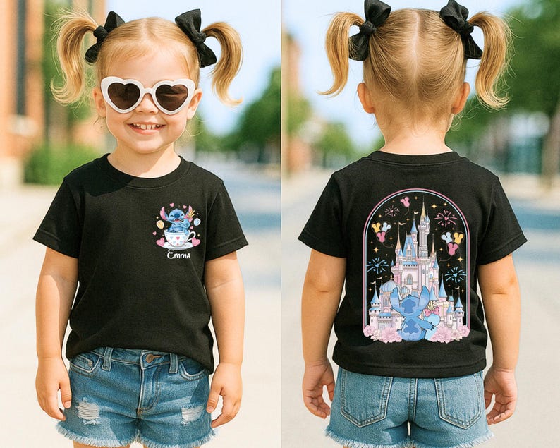 May include: Black t-shirt with a cartoon graphic of a blue alien in a teacup on the front and a castle design on the back. The shirt is worn by a young child with blonde pigtails and heart-shaped sunglasses.