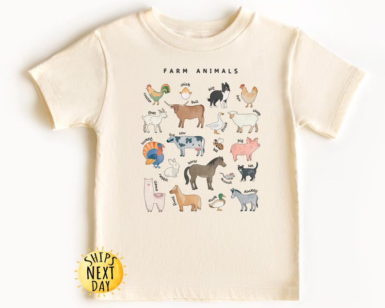 K&ouml;nnte beinhalten: Ein cremefarbenes T-Shirt mit einer Grafik von Nutztieren und ihren Namen. Der Text "FARM ANIMALS" ist oben auf der Grafik in Schwarz gedruckt.