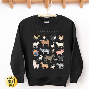 K&ouml;nnte beinhalten: Schwarzer Pullover mit einem wei&szlig;en Aufdruck von Nutztieren und ihren Namen. Der Text "Farm Animals" befindet sich oben auf dem Aufdruck.