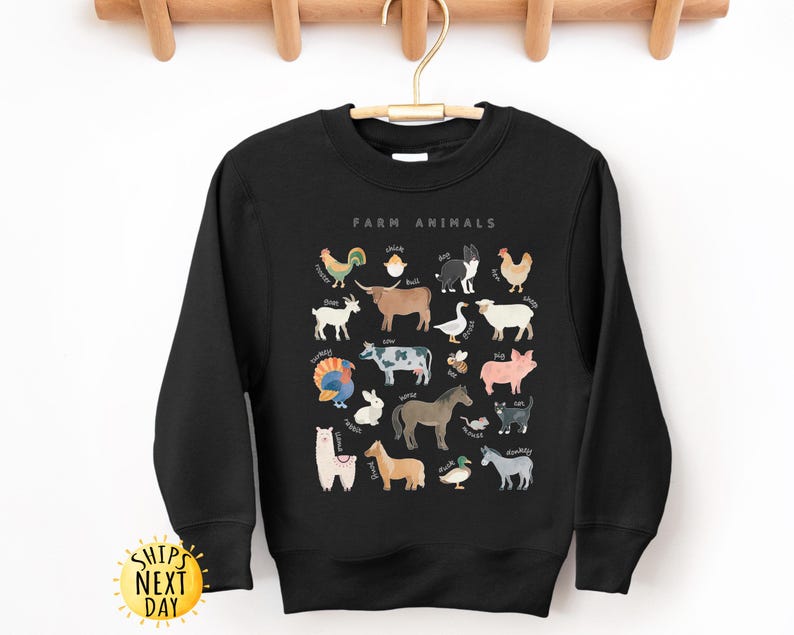 K&ouml;nnte beinhalten: Schwarzer Pullover mit einem wei&szlig;en Aufdruck von Nutztieren und ihren Namen. Der Text "Farm Animals" befindet sich oben auf dem Aufdruck.