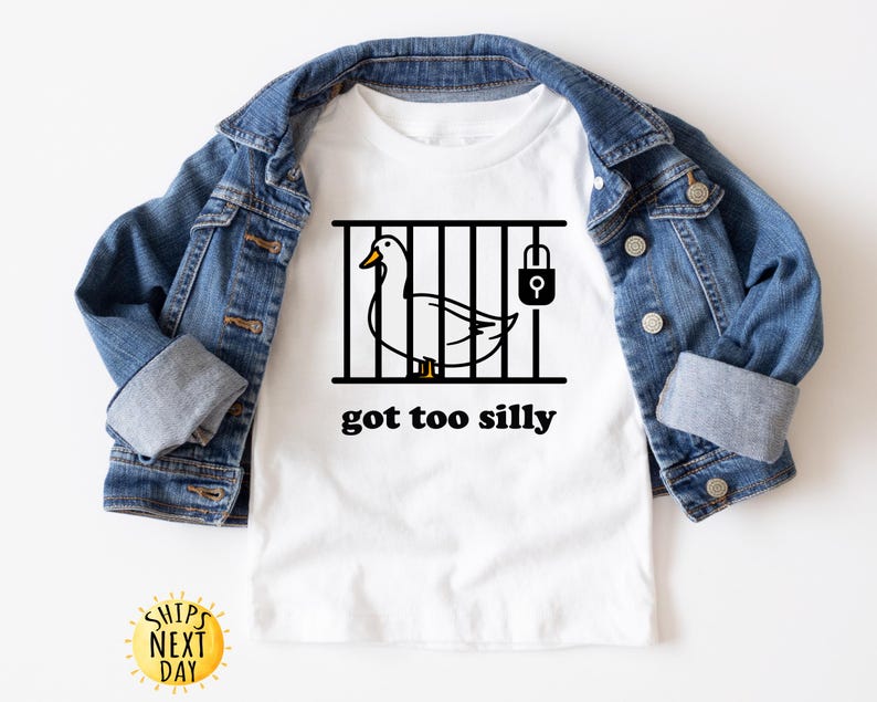 May include: White t-shirt with a black and white illustration of a duck in a cage with a padlock. The text "got too silly" is printed below the image.