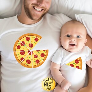 May include: A white t-shirt with a pizza graphic and the text "Ships Next Day" on a white sun. A baby is wearing a white onesie with a slice of pizza graphic.