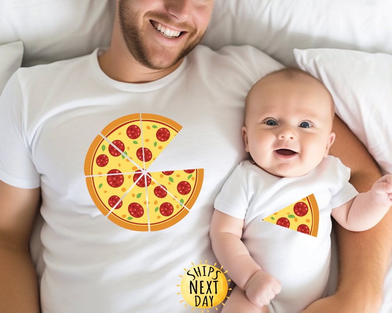 May include: A white t-shirt with a pizza graphic and the text "Ships Next Day" on a white sun. A baby is wearing a white onesie with a slice of pizza graphic.