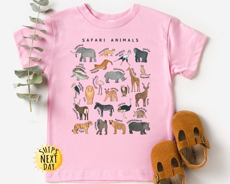 May include: Pink t-shirt with a graphic of safari animals and their names. The shirt has the text "SAFARI ANIMALS" at the top.