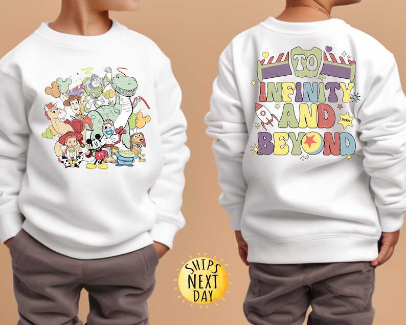 May include: White sweatshirt with a colourful graphic of Toy Story characters on the front and the text "To Infinity and Beyond" on the back.