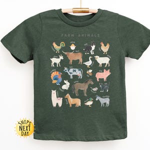 K&ouml;nnte beinhalten: Ein dunkelgr&uuml;nes T-Shirt mit einem grafischen Aufdruck von Nutztieren. Der Text "Farm Animals" ist oben auf dem Aufdruck gedruckt.