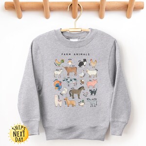 K&ouml;nnte beinhalten: Grauer Pullover mit einem Aufdruck von Nutztieren und dem Text "Farm Animals" auf der Vorderseite.