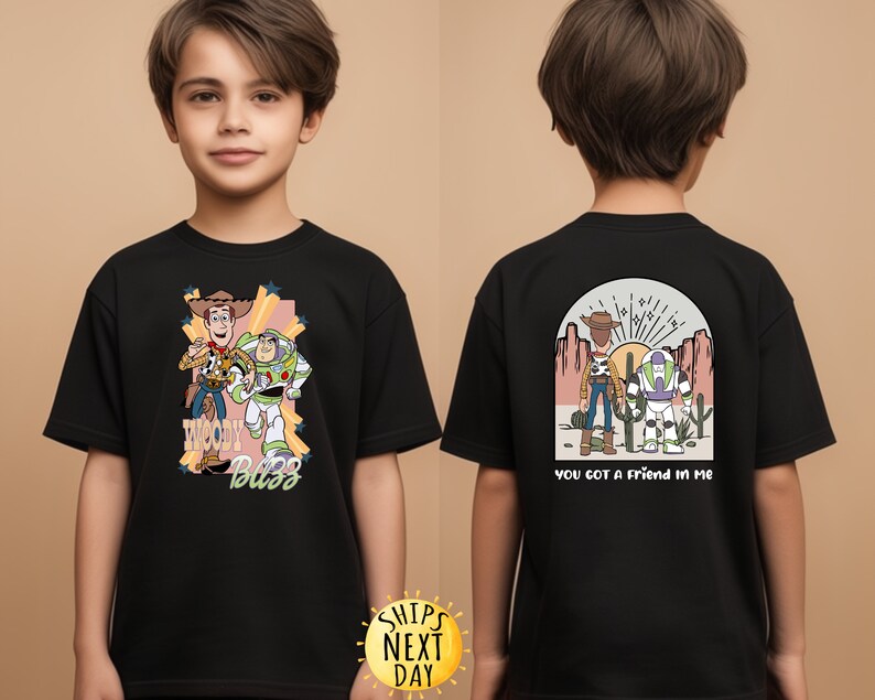 K&ouml;nnte beinhalten: Schwarzes T-Shirt mit einem Motiv von Woody und Buzz Lightyear aus Toy Story. Die Vorderseite des Shirts zeigt "Woody Buzz" und die R&uuml;ckseite "You got a friend in me".